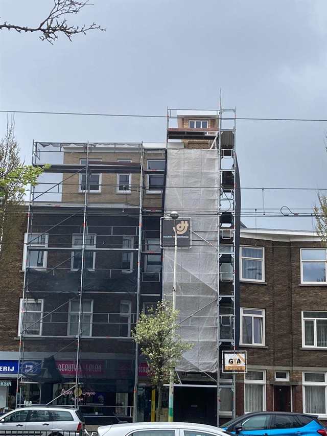 Pand met nieuwe dakopbouw in de steiger, gezien vanaf de straat