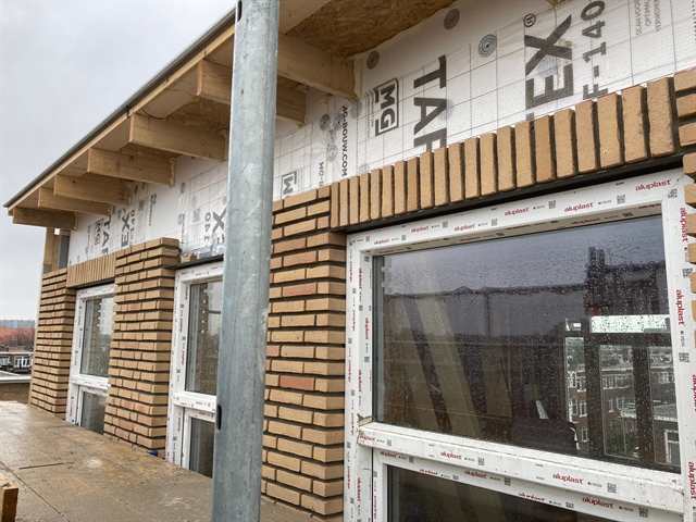 Gevel van een dakopbouw met nieuw kozijn, nog in het plaatmateriaal