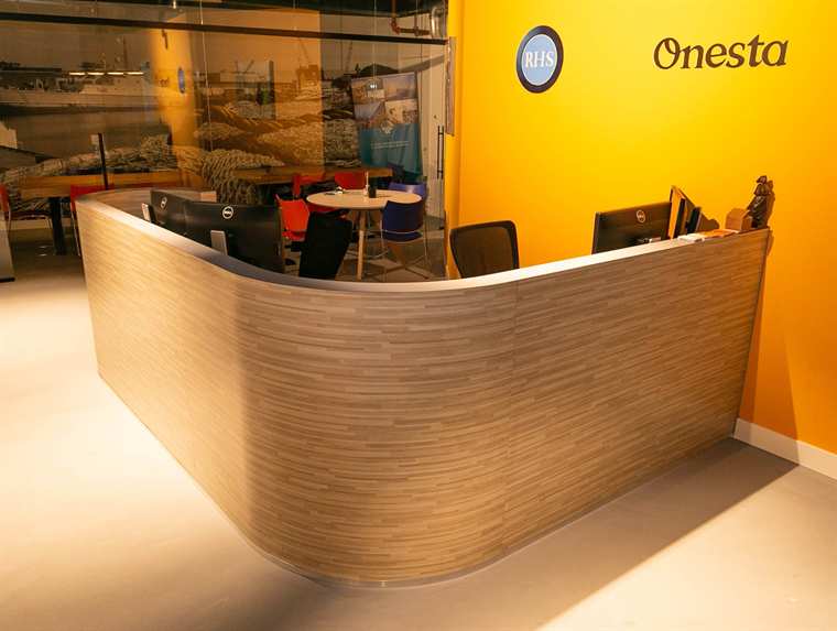Gebogen houten receptiebalie in een kantoorentree